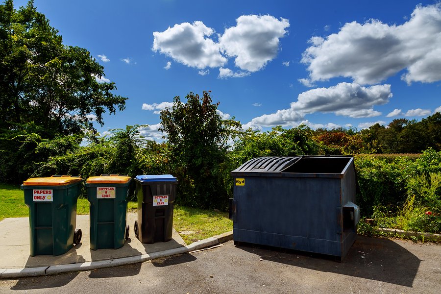 a large garbage container and three small garbage containers